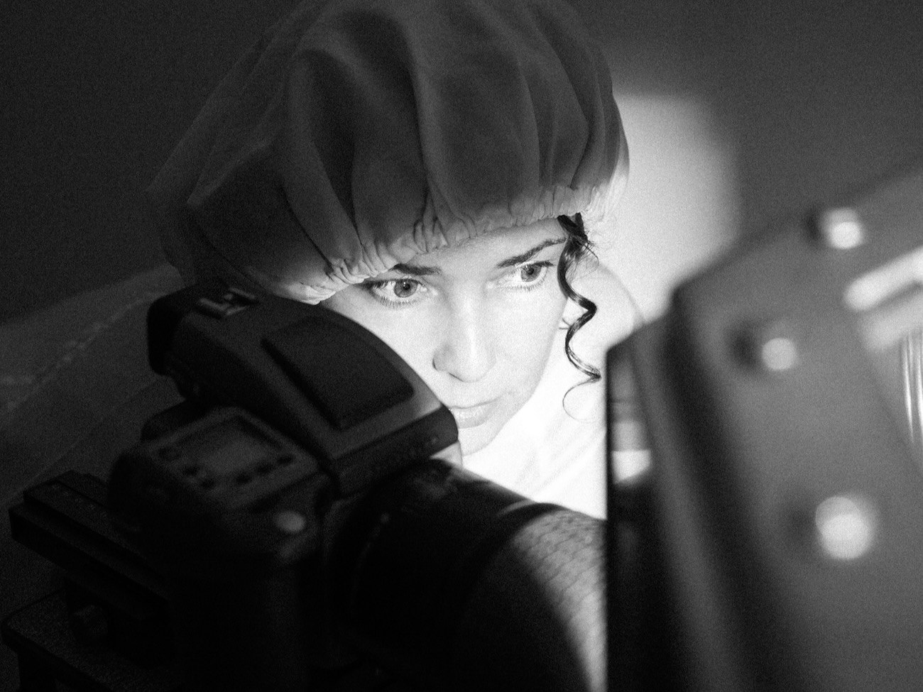 black and white image of erika blumenfeld behind a camera