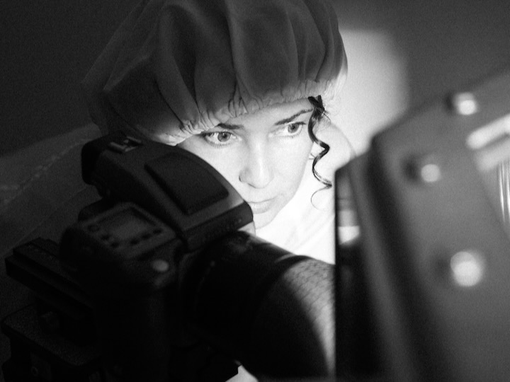 black and white image of erika blumenfeld behind a camera