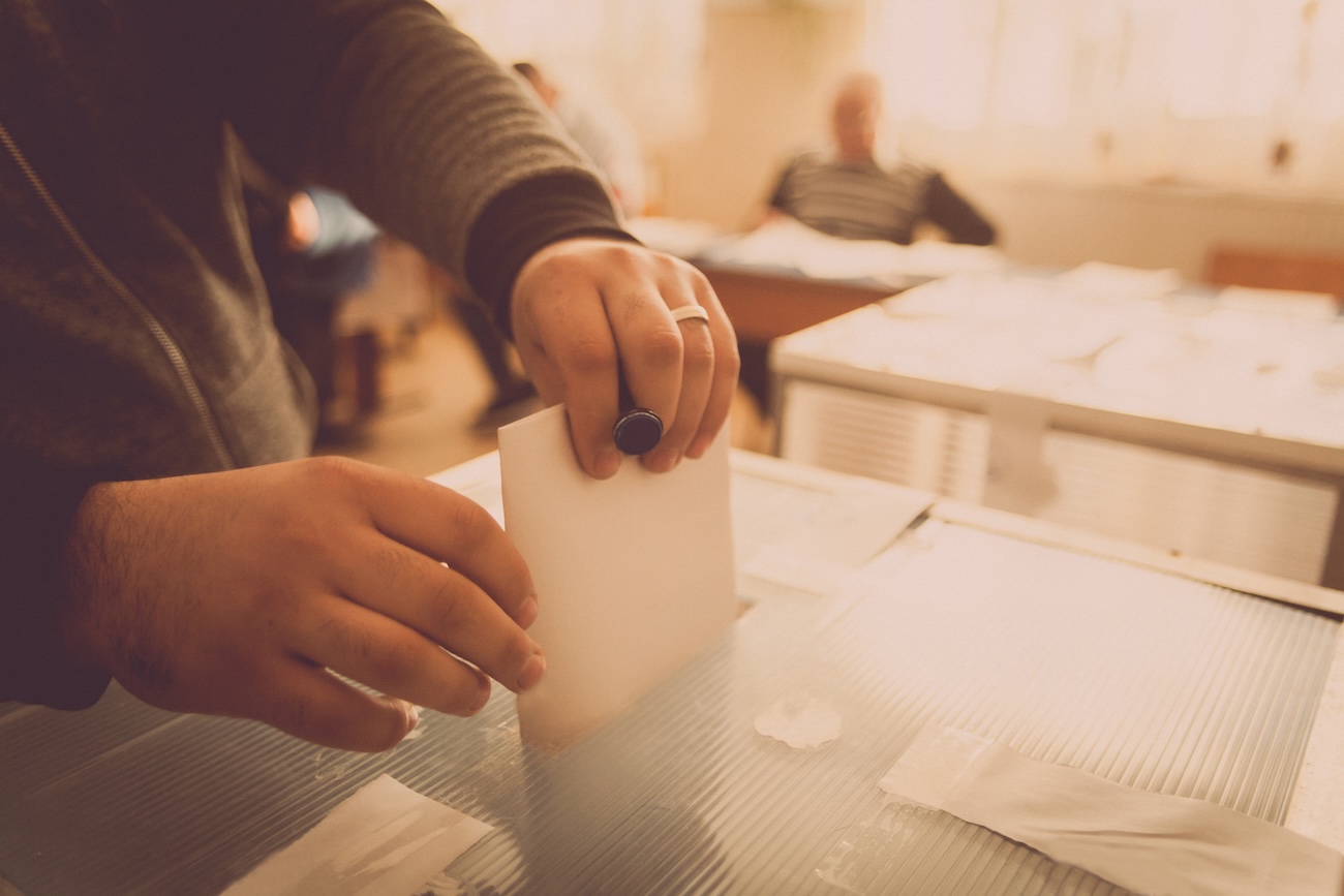 getty image hand putting vote into ballot box