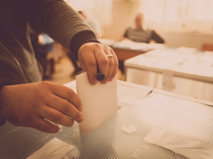 getty image hand putting vote into ballot box