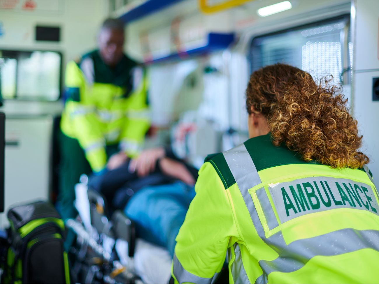 first responders loading a patient onto an ambulance