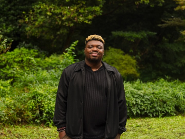 Bryan Washington standing in a green field