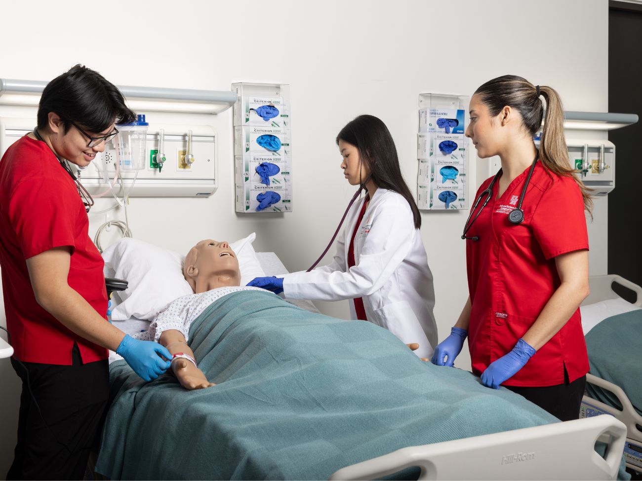 nursing students practicing on a mannequin patient