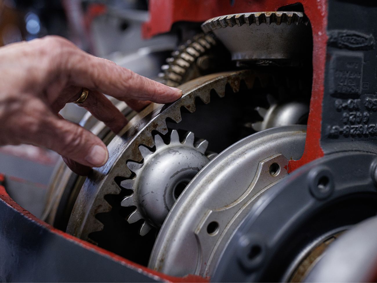 finger pointing to a cog inside an engine