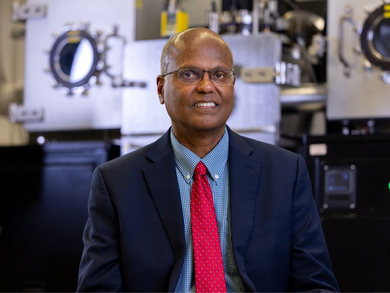 professor selvamanickam in coat and tie in his superconductivity lab at uh