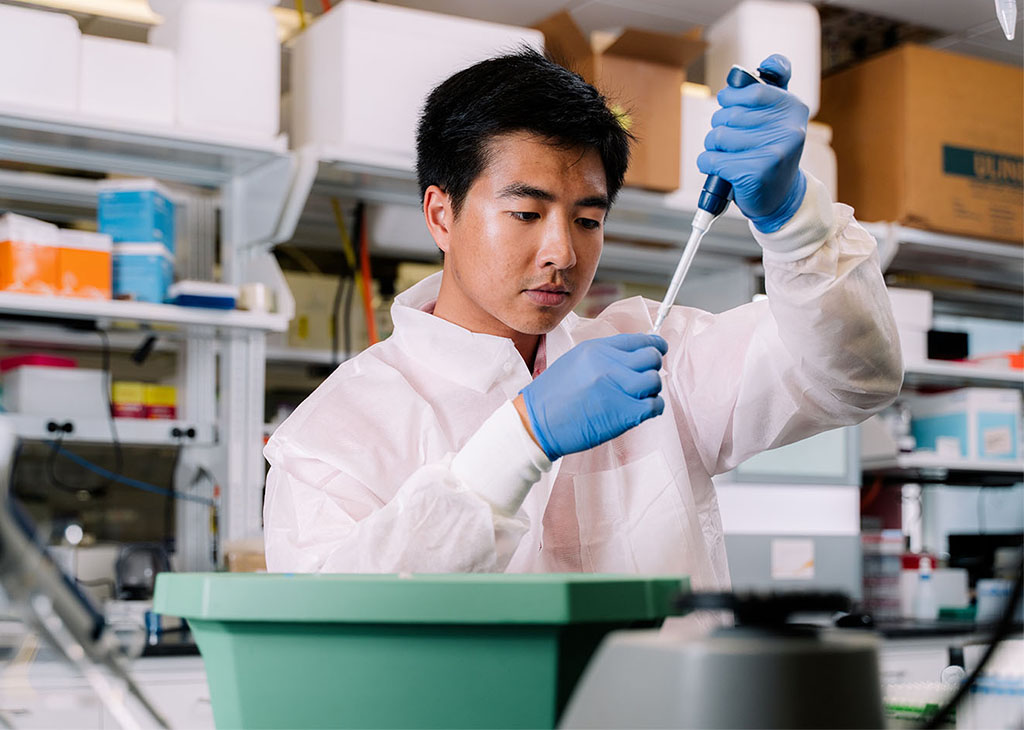 UH biology student Brandon Than examines samples in the lab.