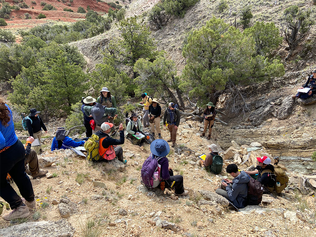 Students at their very first outcrop in Field Camp taking advice from Professor Tom Kalakay on refining their lithologic descriptions. Photo Credit: Jack McLaughlin, TA