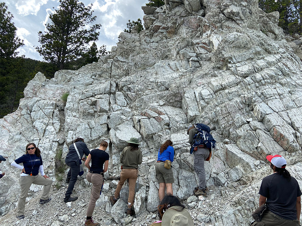 Students observe an anorthosite with pyroxene banding. Photo credit: Jack McLaughlin, TA