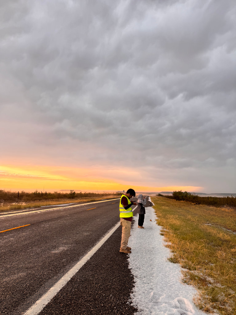 Students enjoying the hail after the storm, with a spectacular orange sunset lighting up the sky later that evening.