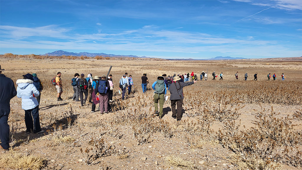 Students hike down to previously flooded locations with sediment coring equipment. Photo credit: Korien Oostingh