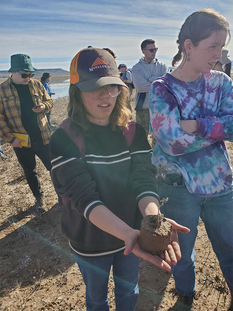 Wharton Junior College student holds partial section of sediment core showing a plant. Photo credit: Noam Mullinax