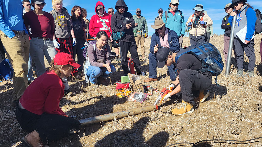 Dr. Brandee Carlson guides students on how to extract a sediment core. Photo credit: Korien Oostingh