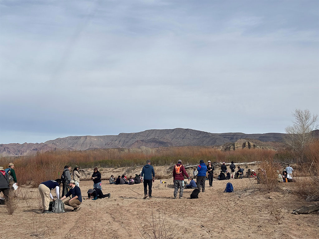 Groups gathered around the river take a quick lunch break. Need to build strength before we start digging in the sand. Photo credit: Evanna Alstrom