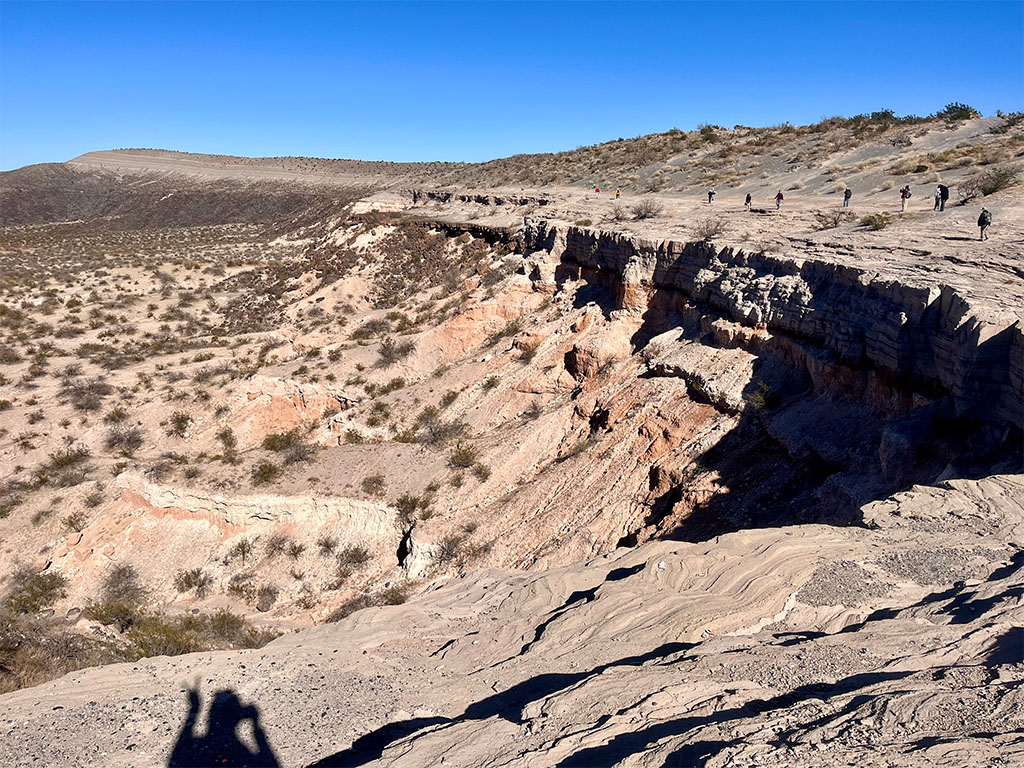 Trail of students walking along crater rim. Winter TA in bottom shadow with super cool peace sign. Photo credit: Jamie Jetton