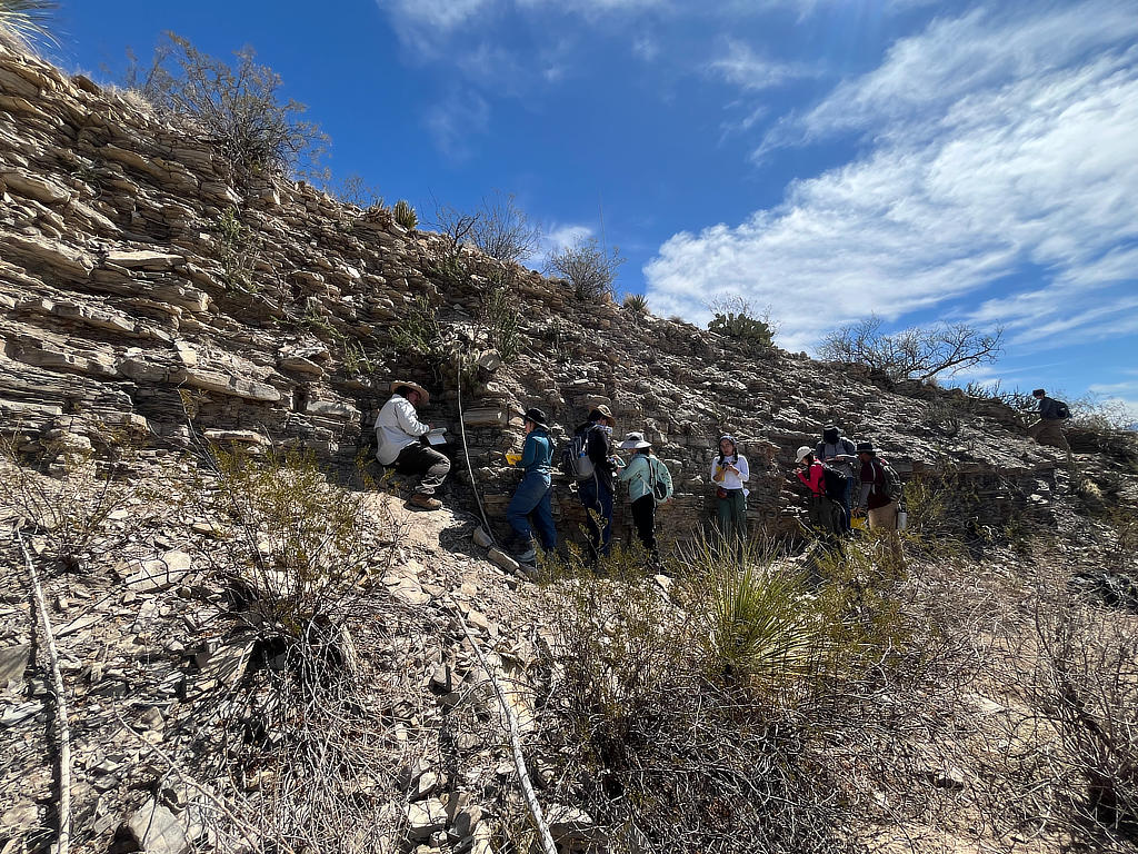 Photo Credit: TA Abe Okayli-Masryk - Students putting their noses to the rock and measuring fractures, faults, and bedding surfaces of the Eagleford Shale.