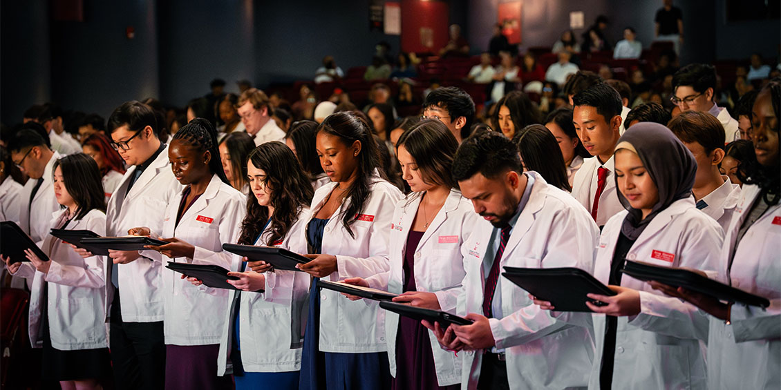 students reciting oath of pharmacist at white coat