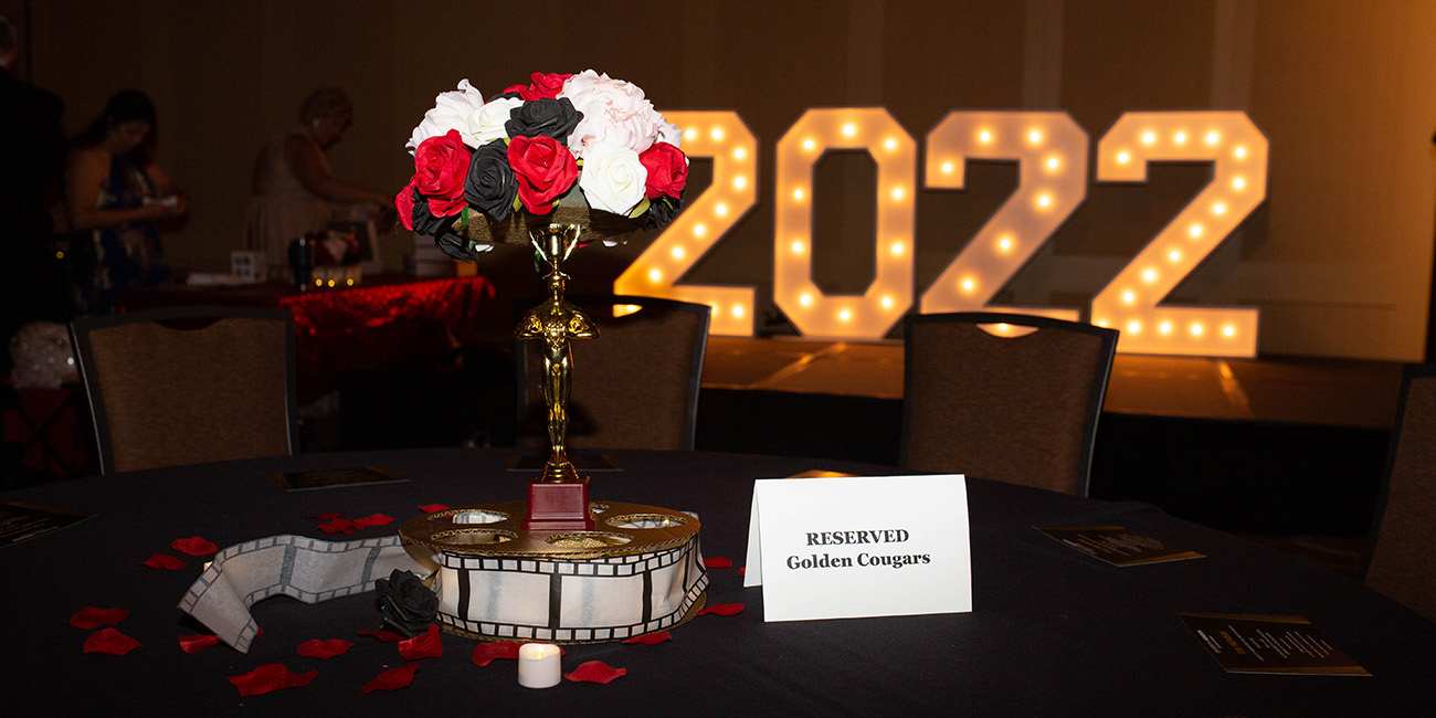 Year 2022 in lights with flowers and Reserved Golden Cougars table card