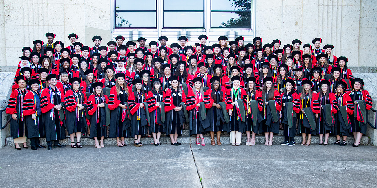 UHCOP Class of 2022 Graduates on steps in caps and gowns