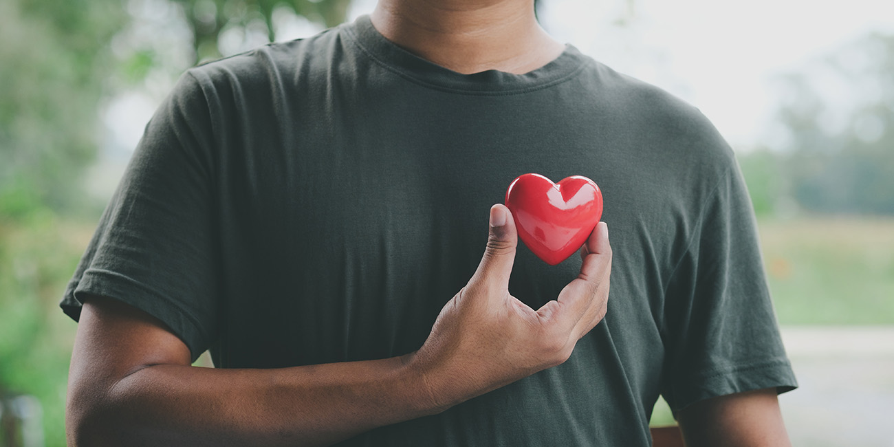 man holding heart next to his next