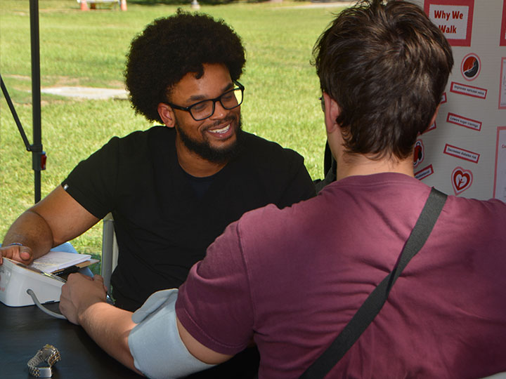 Pharm.D. student Bryant Flowers conducts a blood pressure screening on a UH student.