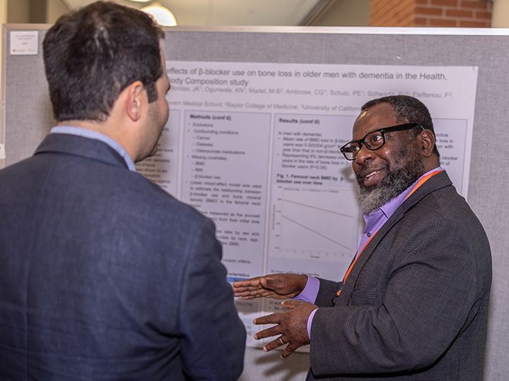 Des Bordes talks to attendee at poster