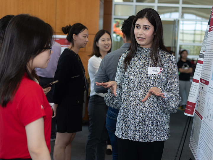Khan explains poster to attendees