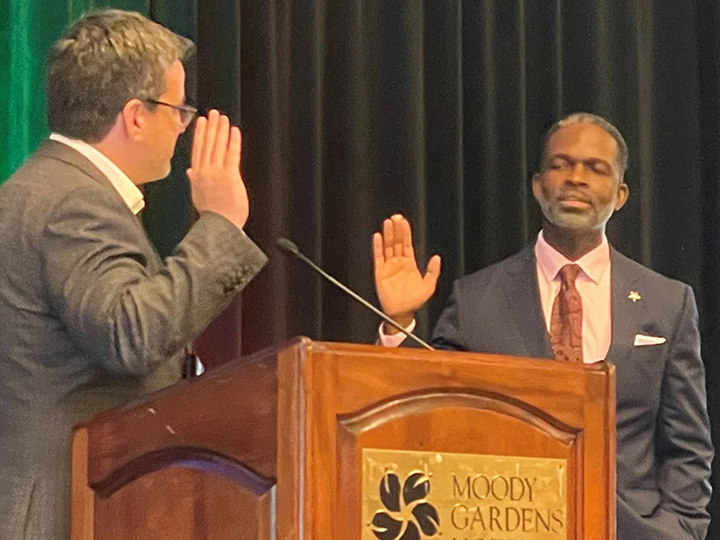 Cox with hand raised taking oath of office