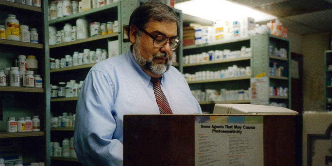 archival photo of Cuellar at pharmacy counter