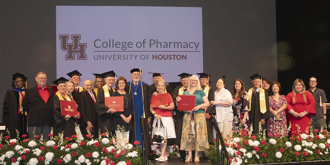 Golden Cougar alumni and family members on stage with Dean Pritchard