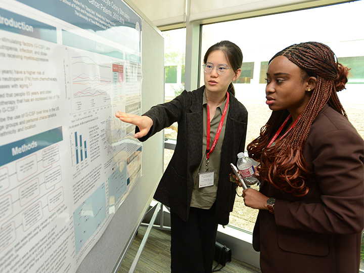 poster presenter talking with attendee