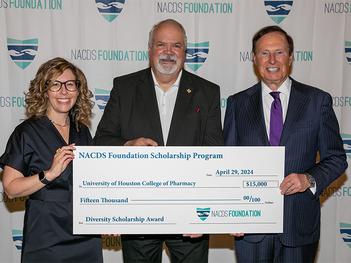 Roszak, Pritchard and Anderson holding large check