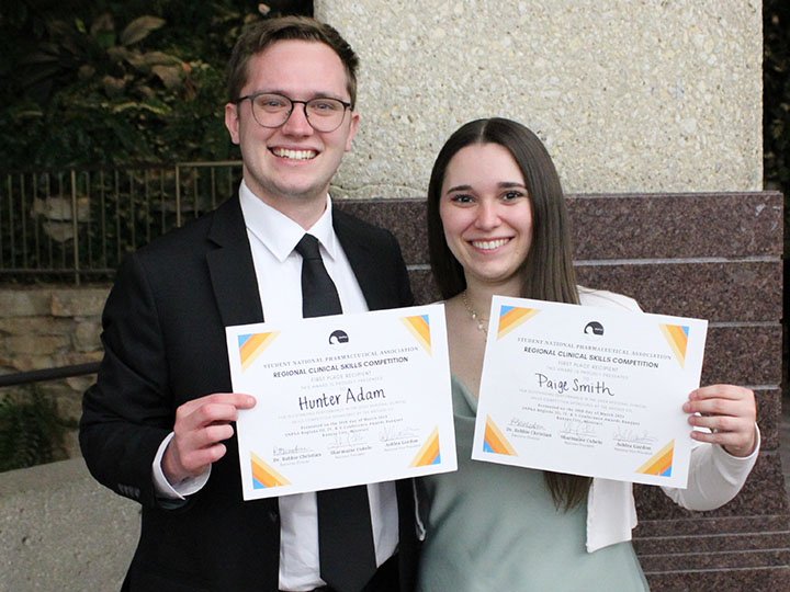 Adam and Smith holding certificates