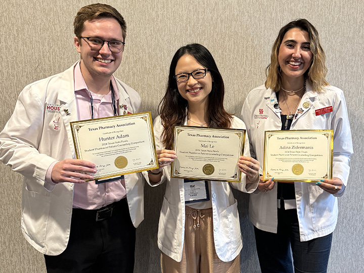 Adam, Li and Zidermanis hold their certificates