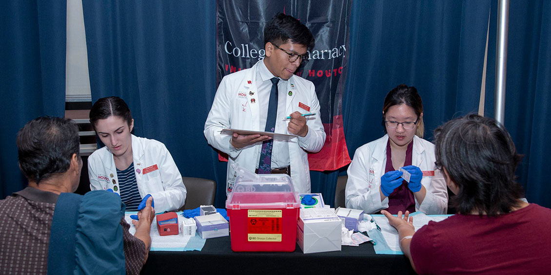 students interacting with patients at health fair