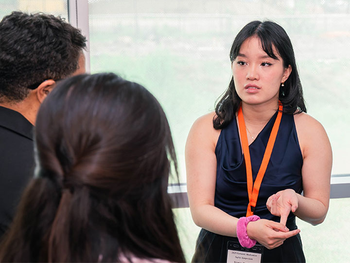 Phan-Tran discussing poster with attendees