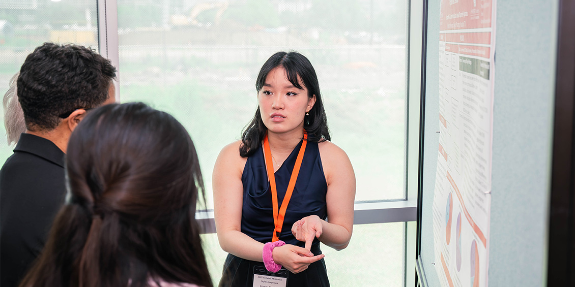 researcher discussing poster with attendee