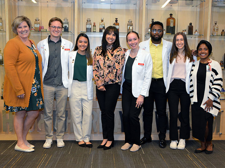 PLS faculty co-advisors and officers stand in front of pharmacy museum