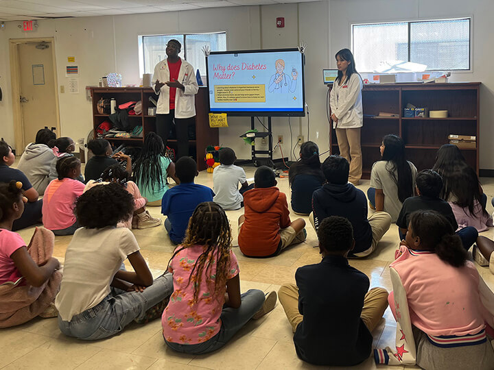 students presenting to elementary school students