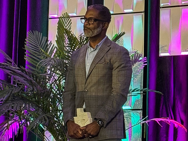 Cox holds plaque on stage