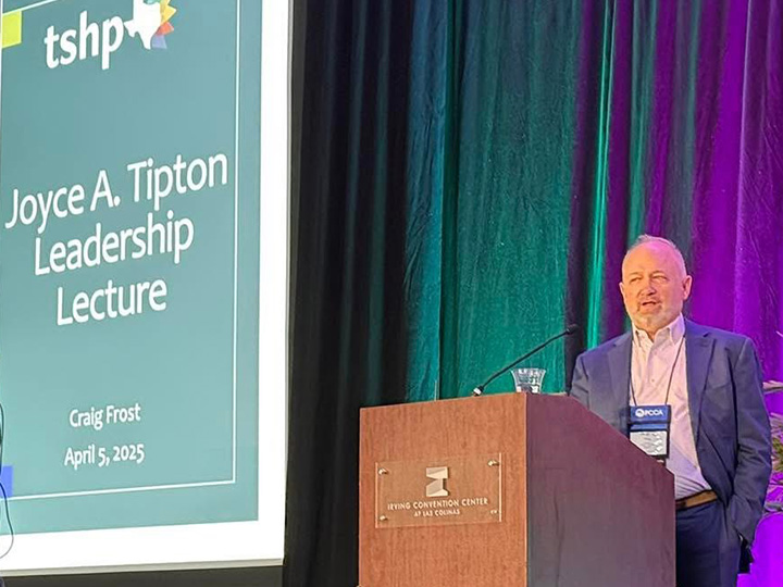 Frost speaking at podium