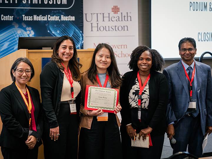 Yinan Wang is congratulated for her Best Podium Award by symposium co-chairs