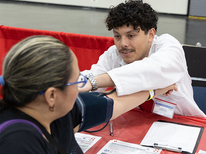 student conducting blood pressure screening