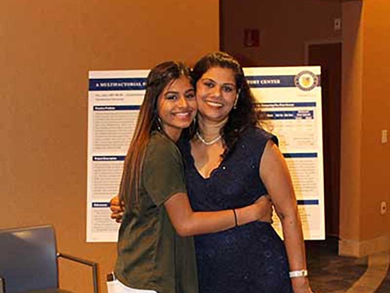 A mother and daughter hug each other.