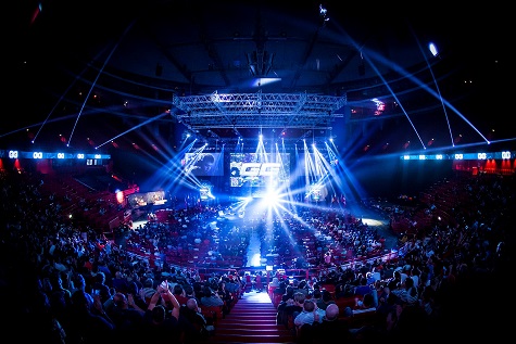 A large arena filled with people warching a display of lights at the stage