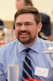 Portrait of a man with a bread wearing glasses