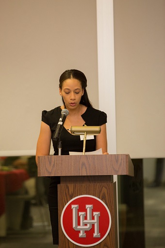 Photograph of a woman in black speaking at a odium.