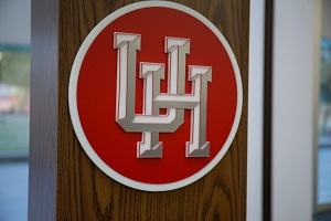 Close up of a panel with a UH logo on a wooden podiium.