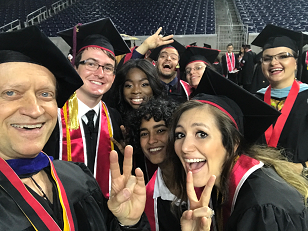 A group of people wearing graduation regalia celebrating