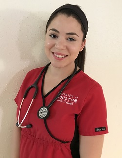 Portrait of a Hispanic woman smiling in a red nursing scrub with a stethoscope hung over her neck.