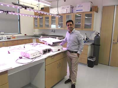 Picture of a professor smiling next to donated equipment.